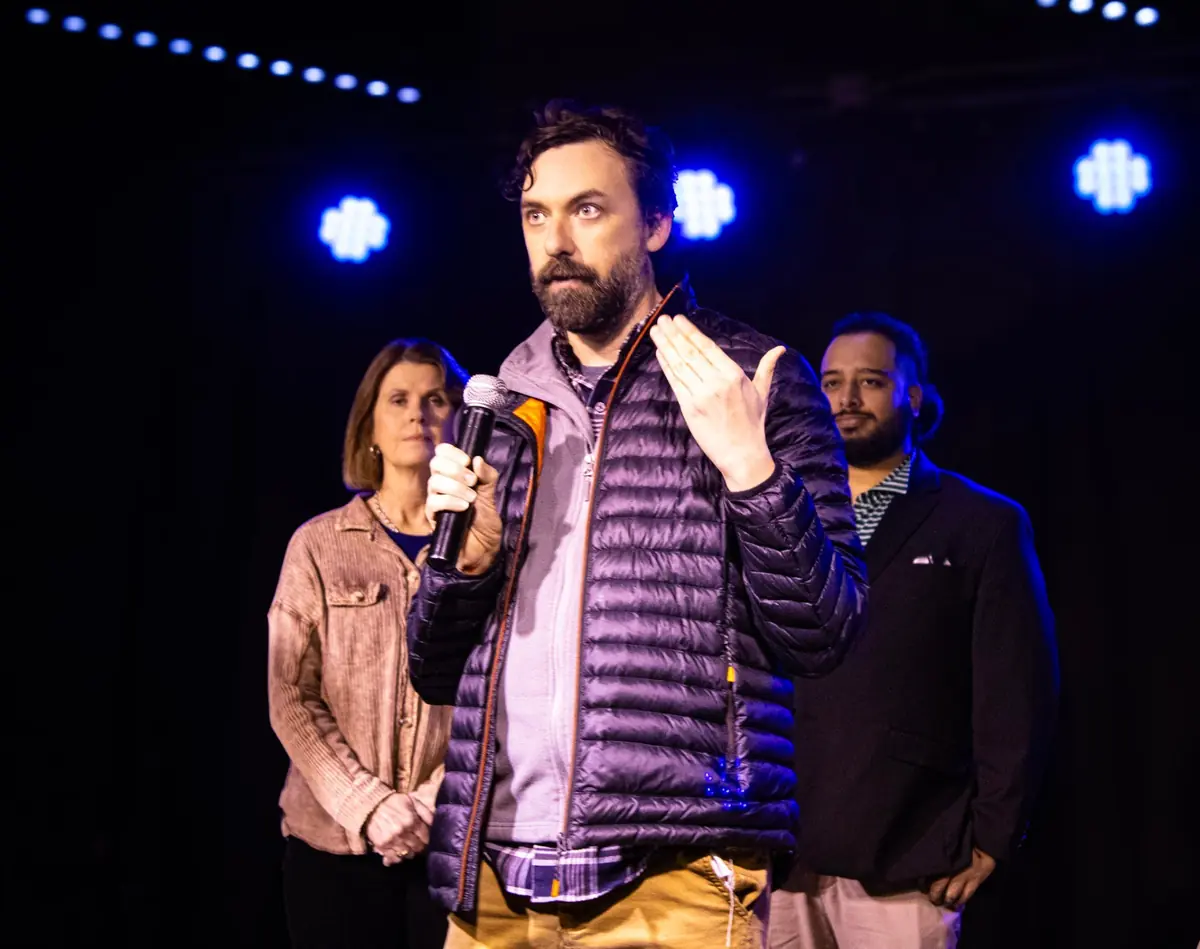 Matt Robinson speaking with a microphone on stage at a Birmingham marketing event