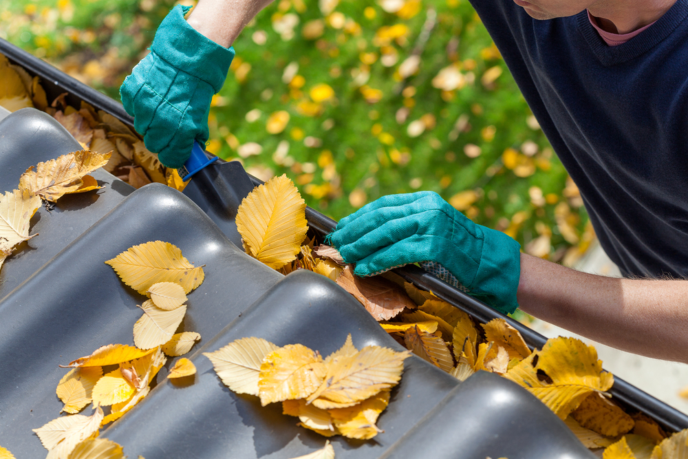 man cleaning gutters who works for a home service company