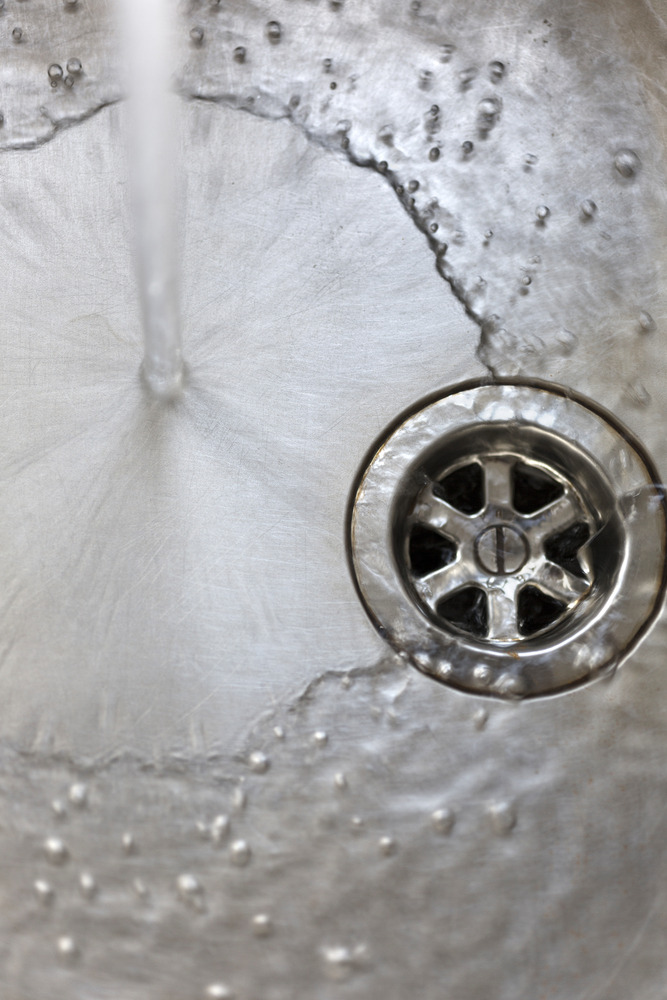 image of drain with water pouring in